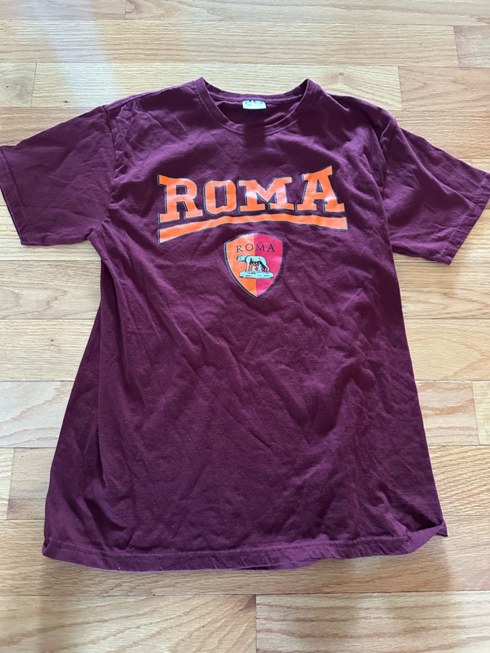 Roma Maroon Tee with Orange Crest Graphic. Size Medium.